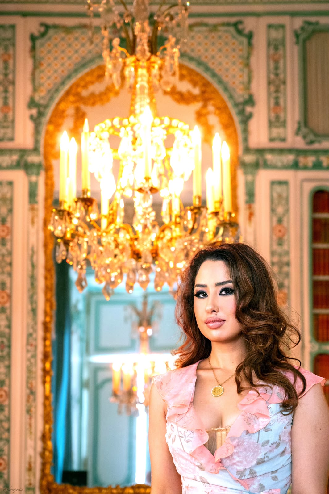 Dr Eman Bensalem in a palace salon beneath a crystal chandelier